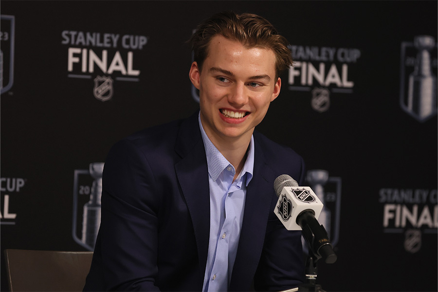 Der Eishockeyspieler Connor Bedard lächelt bei einer Pressekonferenz